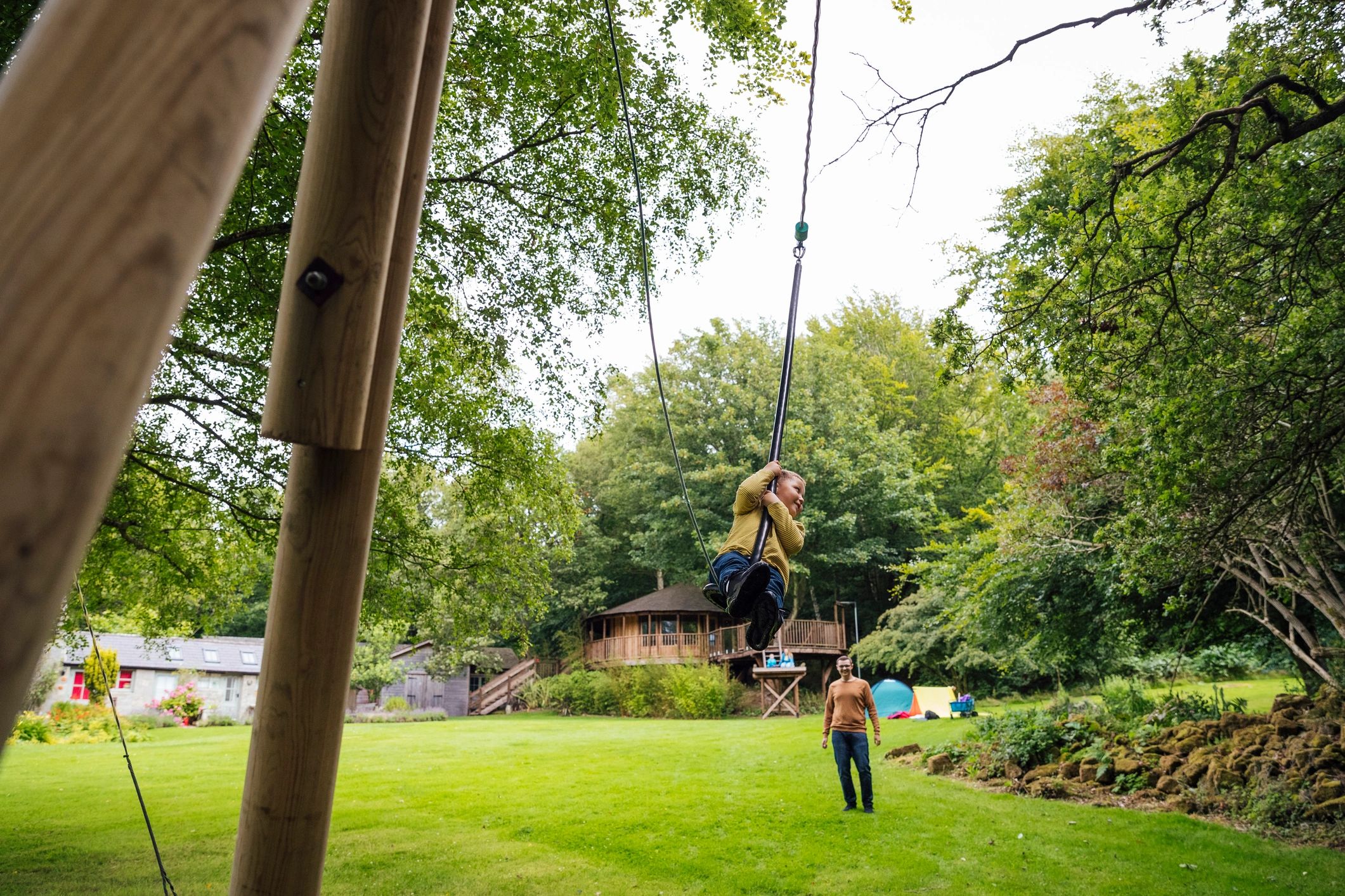 Father pushing child on a zipline swing